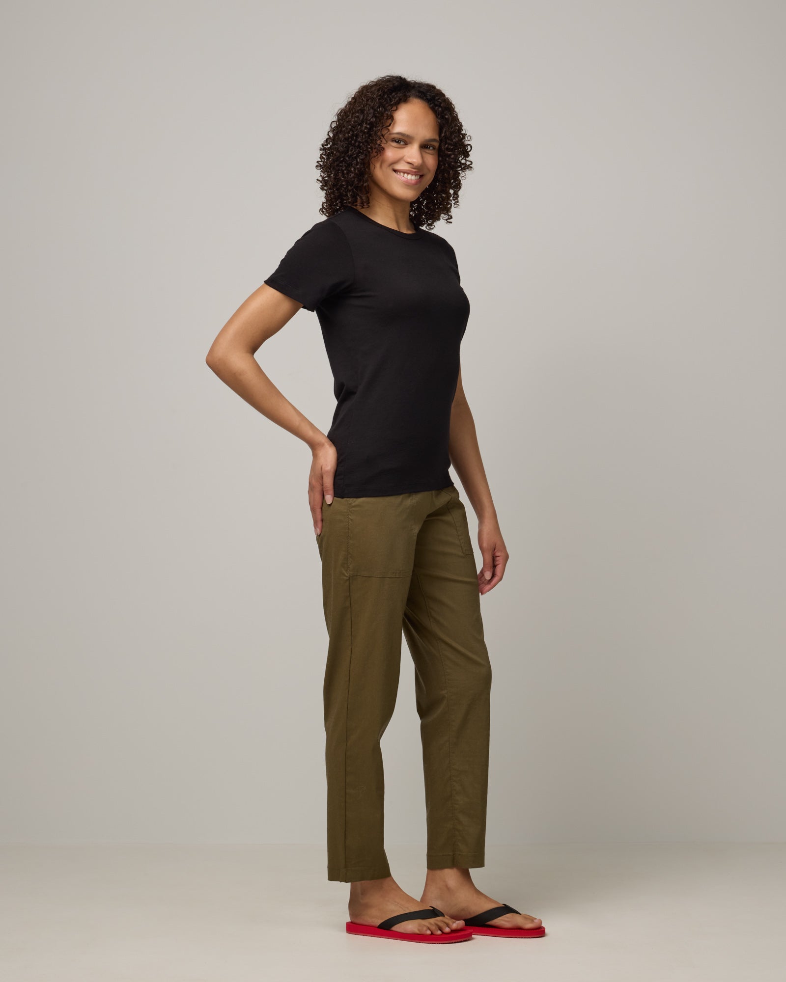 Model wearing Cara 100% Wool Fitted Tee in Black. Cara 100% Wool Fitted Tee is a merino wool short sleeve, crew neck, slim fit tee available in sizes XS-3X.